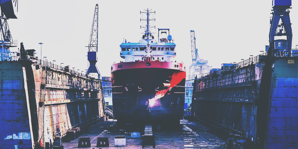 Image of red and white ship being dry docked