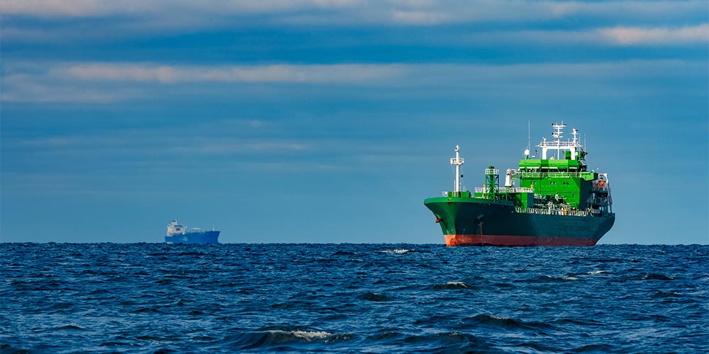 Green vessel crashing through the waves